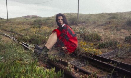 Lily Costa sitzt auf Bahngleisen