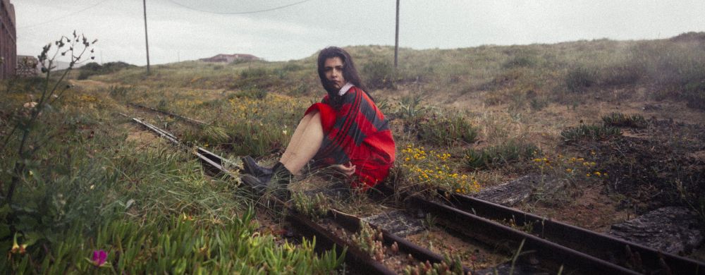 Lily Costa sitzt auf Bahngleisen